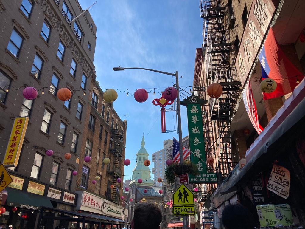 This is taken in Chinatown in New York. Although we can easily see that Chinatowns  worldwide are symbols of inclusion and diversity, we usually consider them as mini-China  within a foreign country. However, reality shows more of an intermingling between  Chinese and foreign cultures, which enhances diversity even more. In this photo, not only  do we spot the traditional lanterns across buildings, but we also note the Chinese and  English signs side-by-side. The building styles from various countries, as well as the  hanging of American flags in Chinatown in the United States, perfectly demonstrates how  multi-layered inclusion can be.